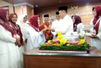 Wakil Wali Kota Bekasi Abdul Harris Bobihoe menyerahkan potongan tumpeng kepada Ketua GOW Kota Bekasi, Hj Tati Arianingsih pada HUT ke 21 GOW Kota Bekasi. (Foto: Doc Redaksi)