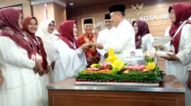 Wakil Wali Kota Bekasi Abdul Harris Bobihoe menyerahkan potongan tumpeng kepada Ketua GOW Kota Bekasi, Hj Tati Arianingsih pada HUT ke 21 GOW Kota Bekasi. (Foto: Doc Redaksi)