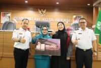 Ketua TP PKK Kora Bekasi Wiwiek Hartono Tri Adhianto memberikan masker secara simbolis dalam acara pertemuan rutin TP PKK Kota Bekasi yang berlangsung di Gedung Nonon Sonthanie, Rabu (9/9/2026).(Foto: Hms Pemkot Bekasi)