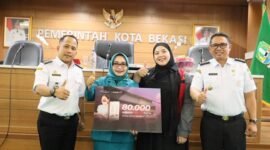 Ketua TP PKK Kora Bekasi Wiwiek Hartono Tri Adhianto memberikan masker secara simbolis dalam acara pertemuan rutin TP PKK Kota Bekasi yang berlangsung di Gedung Nonon Sonthanie, Rabu (9/9/2026).(Foto: Hms Pemkot Bekasi)